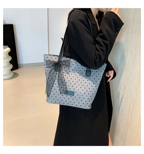 Borsa tote a pois con fiocco in pizzo nero portata a spalla in un interno di tendenza