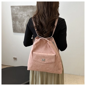 Vue détaillée d'un sac cabas en daim rose avec boucle papillon et bandoulière fine