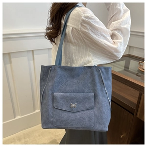 Détail du sac cabas bleu avec boucle papillon en métal et texture délavée vintage
