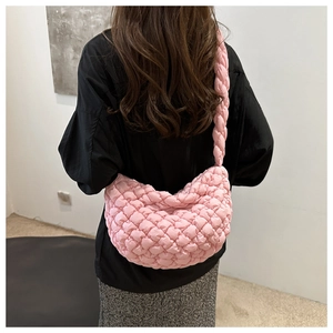 Détail du sac hobo rose matelassé montrant le tissu texturé et la large bandoulière