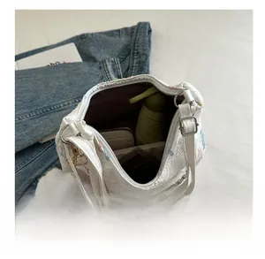 Intérieur spacieux du sac cabas blanc brodé avec détails d'un parapluie et portefeuille