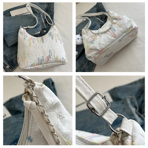 Détails du sac fourre-tout blanc avec broderies colorées et accents de chaîne en métal