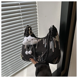 Détail du sac cabas noir avec broderie zigzag, chaîne métallique et pendentif nuage