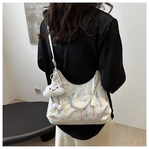 Détail du grand sac cabas blanc matelassé avec franges colorées et chaîne argentée