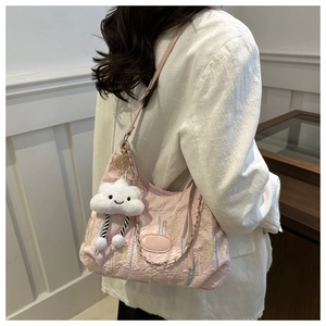 Pink quilted tote with colorful stitching details and a cute white cloud plush pendant