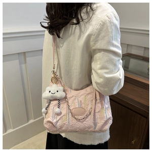 Sac fourre-tout matelassé rose avec broderie florale et breloque nuage sur un mannequin