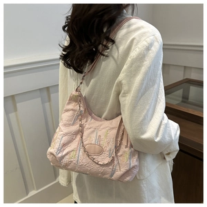 Detail of pink embroidered tote bag featuring colorful stitching and metal chain strap