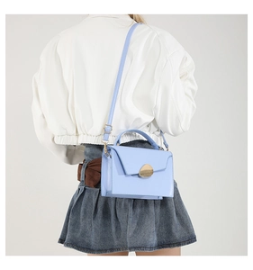 Back view of model wearing a light blue square crossbody bag with gold buckle