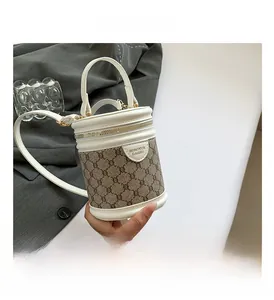 Detail of vintage beige bucket bag with brown monogram pattern and top handle