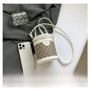 Detail view of a vintage monogram bucket bag with leather trim and phone for size reference