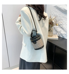 Detail of vintage bucket bag featuring monogram canvas and black leather with shoulder strap