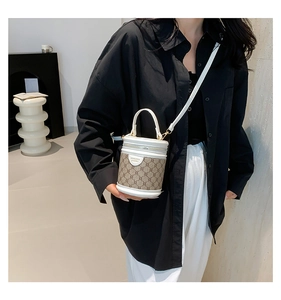 Close-up of a mini cylinder bucket bag with brown monogram canvas and white leather trim