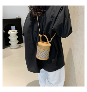 Side view of a mini bucket bag featuring brown leather and monogram canvas on a model