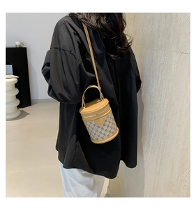 Rear view of a model wearing the classic monogram barrel bag with leather trim and strap