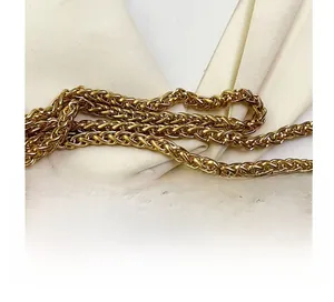 Detailed macro view of high-quality gold hardware chain with woven wheat pattern for bags