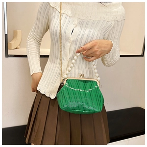 Detail of green pleated shell bag with pearl handle and vintage gold clasp closure