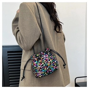 Détail des paillettes colorées et du cordon de serrage noir sur un sac seau élégant