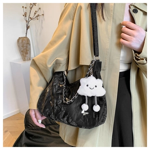 Détail du sac croissant noir plissé avec chaîne en métal et breloque nuage en peluche
