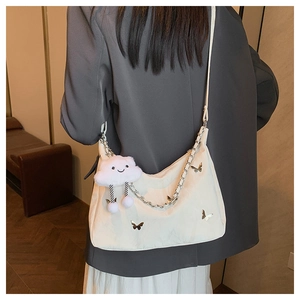 Détail latéral du sac à bandoulière en nylon blanc avec papillons et bandoulière chaîne