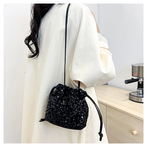 Gros plan du sac seau noir à paillettes avec cordon de serrage et fine bandoulière