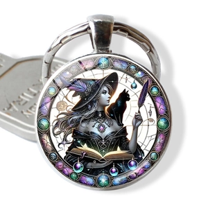 Detail of a round fantasy witch and black cat illustration pendant on silver keychain