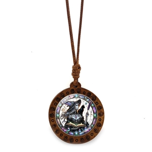 Detail of wooden witch and black cat pendant on vintage brown braided cord necklace