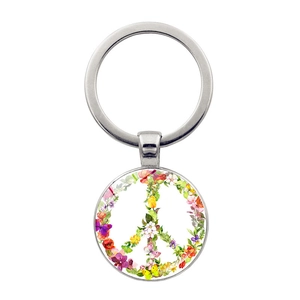 Detailed close-up of a silver peace sign keychain with colorful floral and butterfly patterns