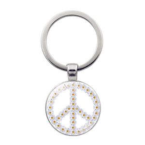 Macro shot of silver alloy keychain with floral daisy peace sign under glass dome