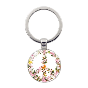 Close-up of a silver peace sign keychain with floral cherry blossom and butterfly design
