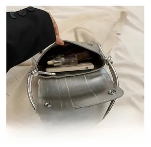 Detail view of the interior capacity and magnetic closure on silver textured handbag
