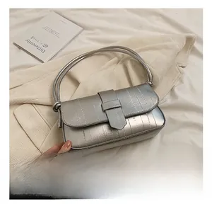 Close-up of metallic silver shoulder bag with magnetic buckle and polished leather texture
