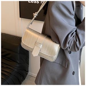 Detail of silver crocodile pattern shoulder bag with a stylish knot handle design