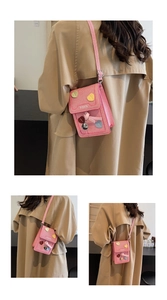 Detail of pink striped mini crossbody bag with heart appliques and ribbon bow