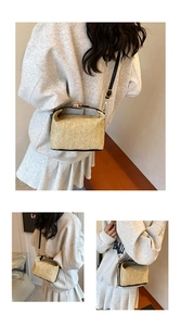 Détail du sac bandoulière en paille tressée avec bordure en cuir noir et fermoir doré