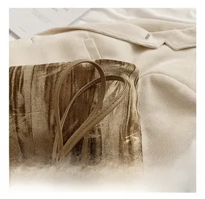 Close-up of velvet handbag featuring marble pattern texture and slim leather handle