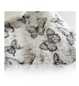 Close-up of white fabric tote bag featuring black butterfly embroidery and soft textures
