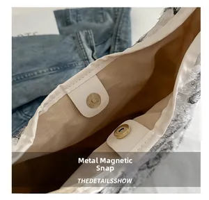 Detail of durable gold magnetic snap closure and plush fabric on a large canvas tote bag