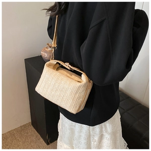Détail de la texture tressée et du fermoir métallique du sac à bandoulière en paille