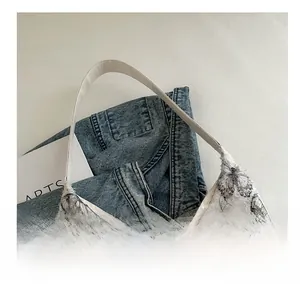 Detail of delicate lace butterfly embroidery and white leather handle on a canvas tote bag