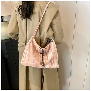 Detail of pink velvet shoulder bag with white bamboo patterns and wooden drawstring charm