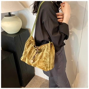 Detail view of velvet shoulder bag with leaf pattern and drawstring closure
