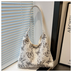 Detail of canvas tote bag featuring textured butterfly print and slim shoulder straps