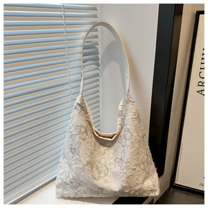 Detailed view of the 3D butterfly embroidery texture on this light gray canvas tote bag