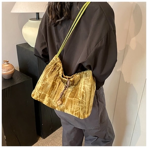 Golden brown velvet shoulder bag featuring wrinkled texture and rope drawstring details