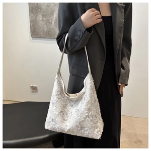 Detail of white plush canvas bag featuring 3D butterfly embroidery with sleek hobo design
