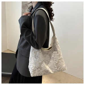 Detail of butterfly-textured cream tote bag featuring high-quality 3D floral surface
