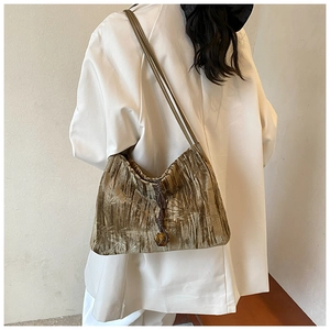Detail of olive green velvet shoulder bag with braided drawstring and amber bead charm