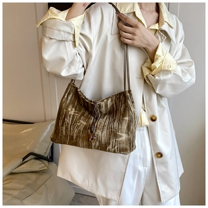 Detail of olive green velvet drawstring shoulder bag with elegant pleated texture and beads
