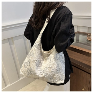 Detailed view of large off-white canvas tote bag with butterfly patterns and textured finish