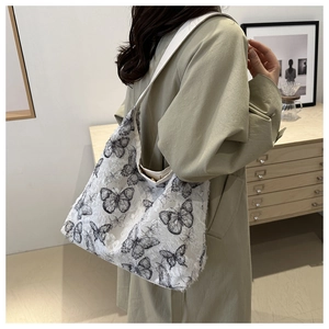 Detail of white butterfly jacquard tote bag with fringe texture on a trench coat model